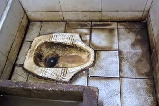 Kloset jongkok kotor di lantai keramik bernoda